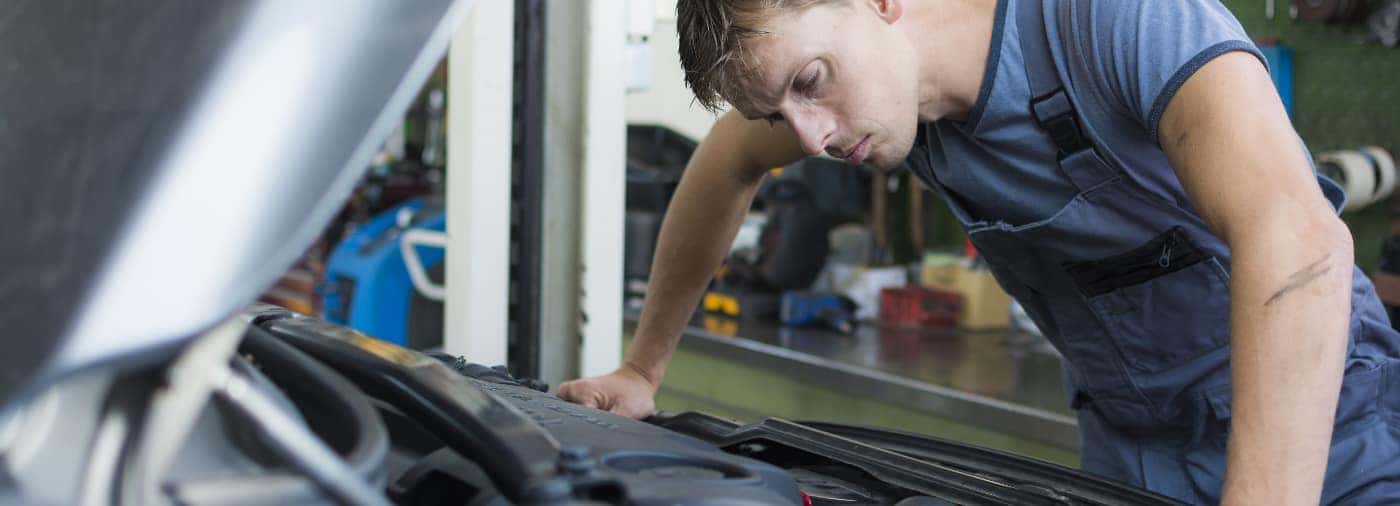 mechanic kijkend naar de motor van de auto