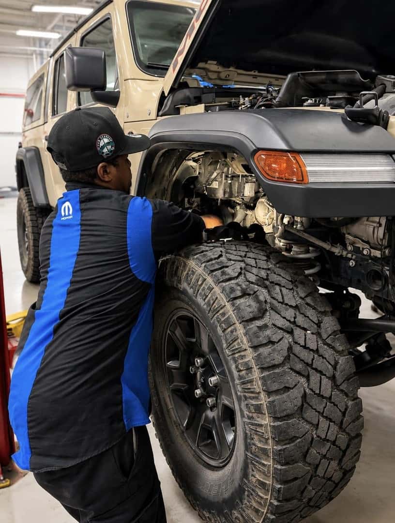 Allen Samuels technician pulling parts alongside a lifted truck in the shop