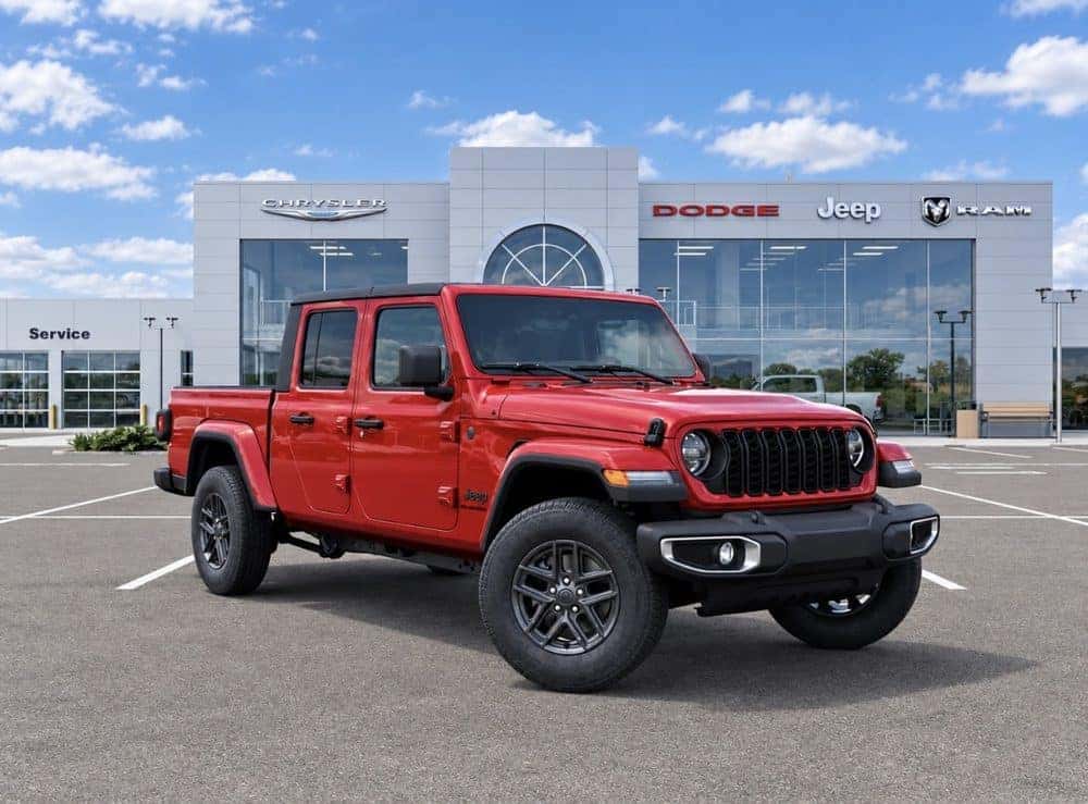 New red Jeep Gladiator parked in front of an Allen Samuels dealership showroom