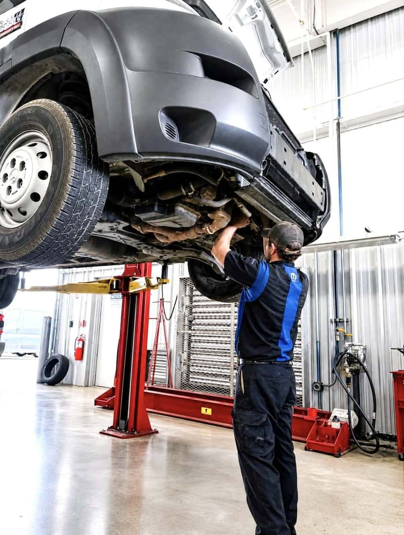 Allen Samuels technician working under a lifted SUV in the service bay
