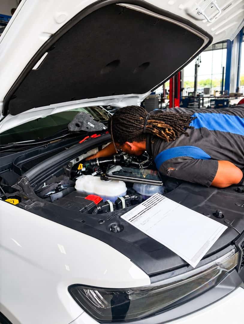 Allen Samuels technician working under the hood of a vehicle in the service shop