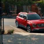 A red 2026 Hyundai venue parked in front of a cafe