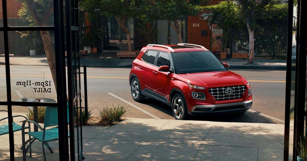 A red 2026 Hyundai venue parked in front of a cafe