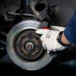 A service technician working on a vehicle's brakes