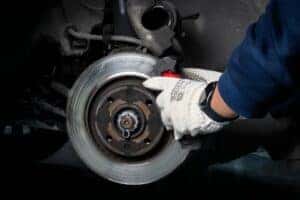 A service technician working on a vehicle's brakes
