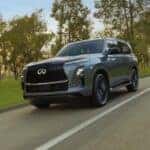 A gray 2026 INFINITI QX80 driving on the road