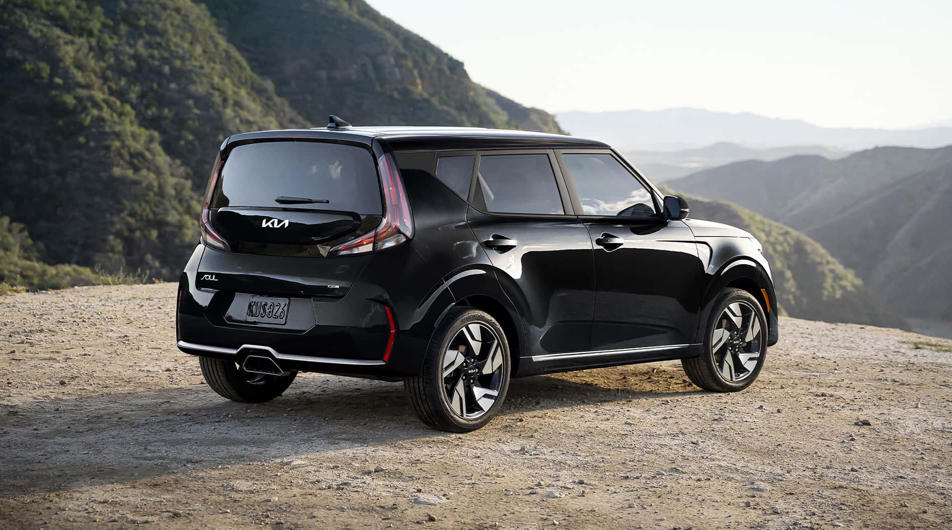 A Black Kia Soul parked overlooking the mountains.