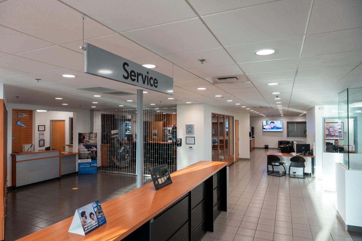 The Service write-up counter inside Elk Grove Volkswagen under the hanging Service sign