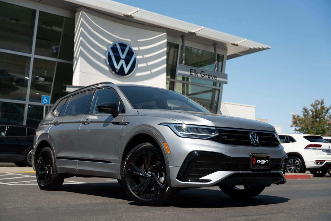 A silver Volkswagen Tiguan with black wheels parked in front of Elk Grove Volkswagen