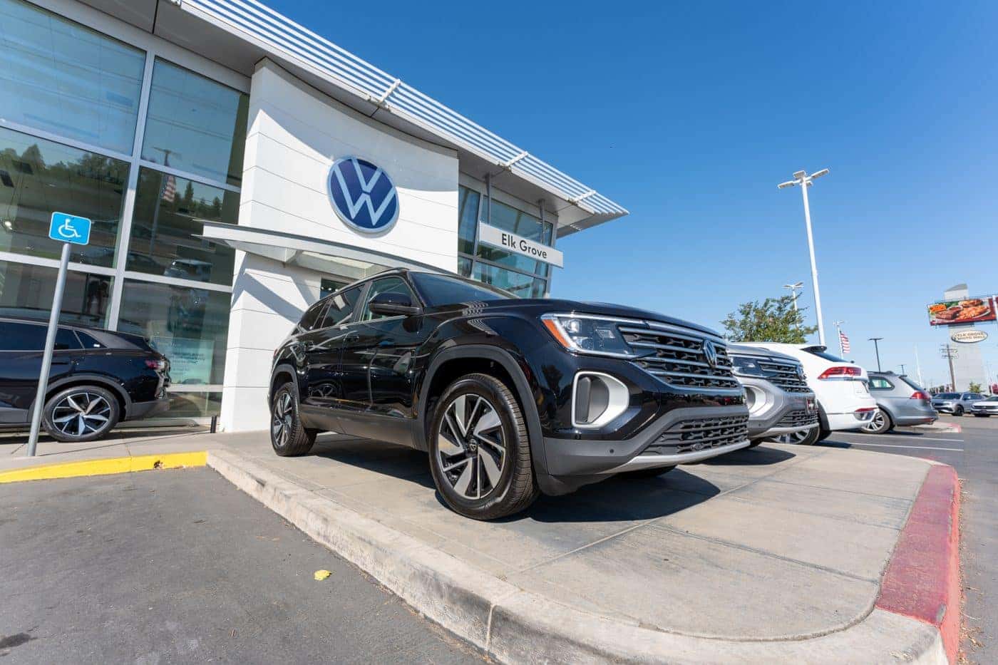 A black Volkswagen Atlas on the front row at Elk Grove Volkswagen, front wheel and tire in close view
