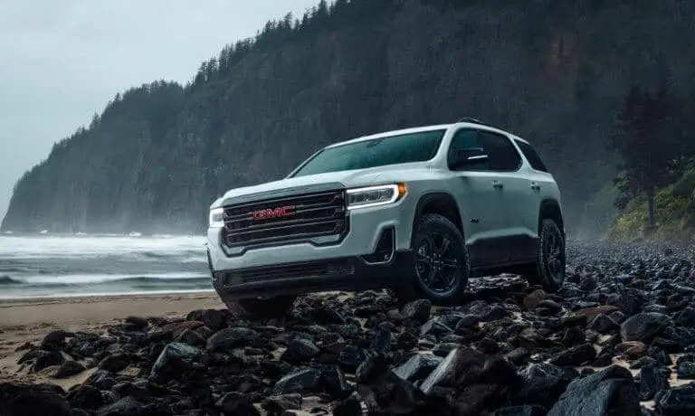 White 2020 GMC Acadia on a beach by a lake