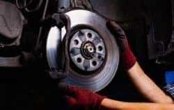 Factory-trained technician performing INFINITI brake service with OEM parts in Jackson Mississippi