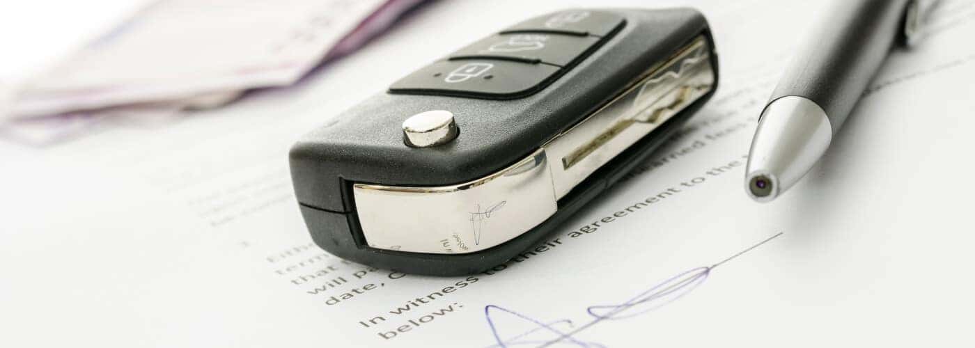 car finance paperwork with key fob and pen