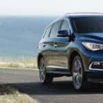 A 2019 INFINTI QX60 driving down a road by the ocean