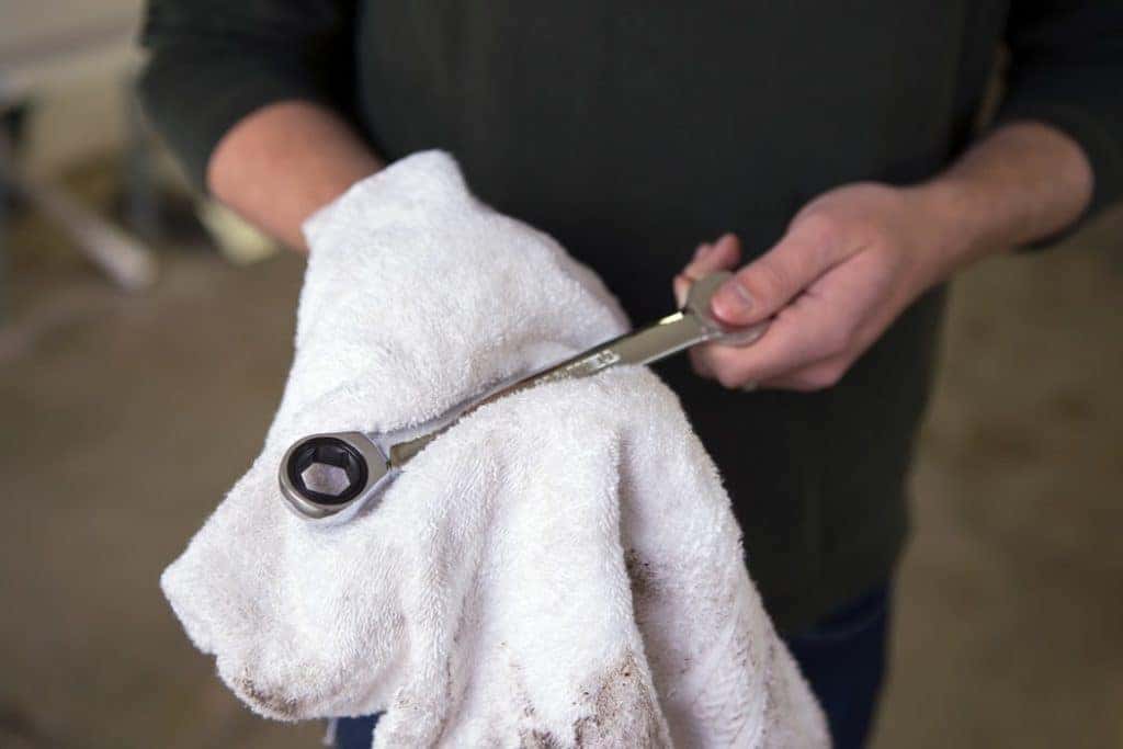 a mechanic at a repair shop in edmond holding a wrench and a towel