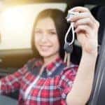 Girl in car showing keys