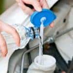 Fill the windshiend water liquid on a car.