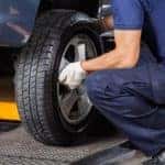 Mechanic Fixing Car Tire At Repair Shop