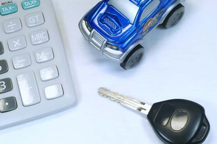 Calculator, toy car, and key representing Mercedes-Benz financing
