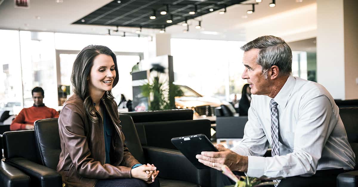 Customer speaking with salesperson at a Mercedes-Benz dealership