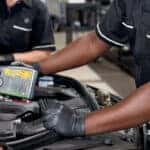 Mechanic changing oil to improve Mercedes-Benz fuel efficiency