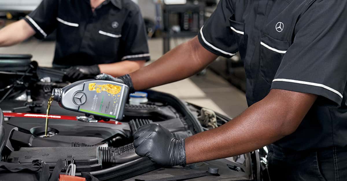 Mechanic changing oil to improve Mercedes-Benz fuel efficiency
