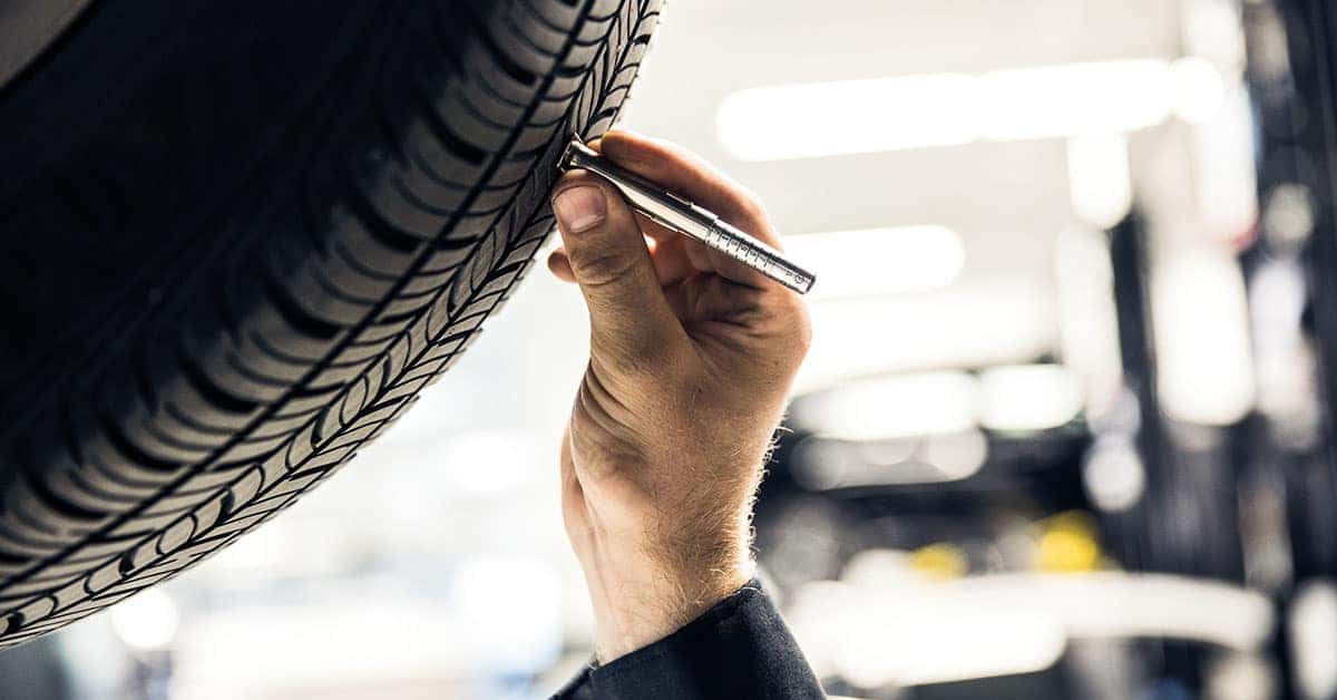 Mercedes-Benz service technician inspecting a tire