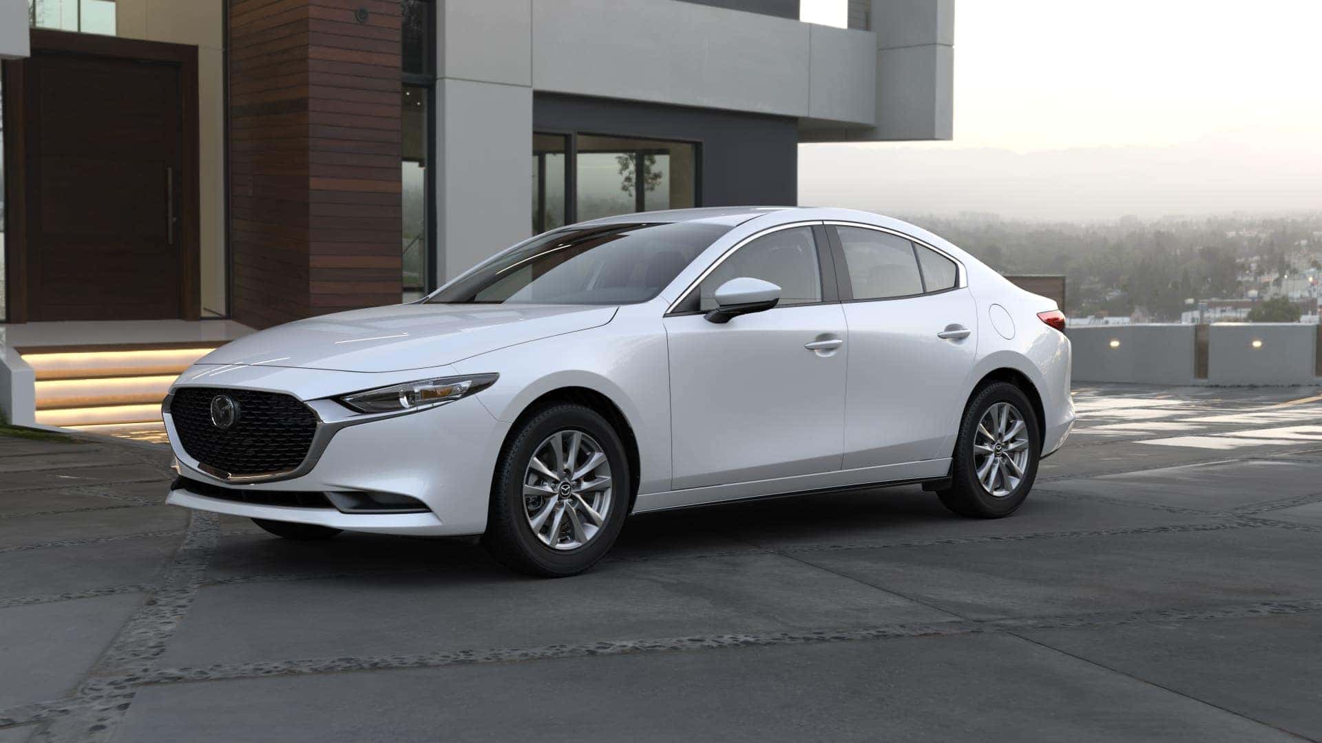 White 2023 Mazda Sedan parked on pavement outside a home. 