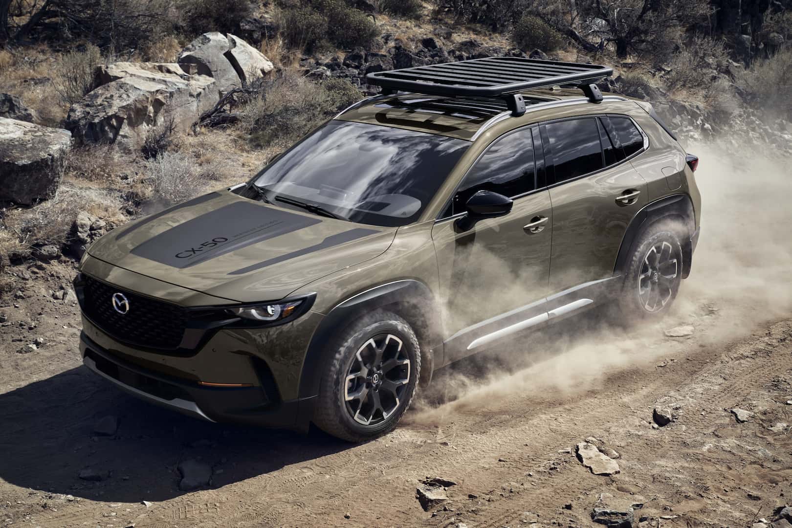 2023 Mazda CX-50 side profile driving in a rocky desert.