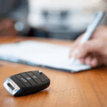 Car key on desk during auto financing paperwork