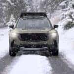 2026 beige mazda cx-50 driving through snowy peaks in the rocky mountains