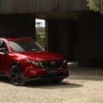 Alt text: 2026 Mazda CX-5 parked near a modern home in a suburban setting