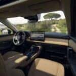 Interior of a Mazda SUV featuring tan leather seating, panoramic moonroof, and premium dashboard design