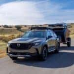 Mazda CX-50 towing a camper trailer on an open road near Littleton, Colorado