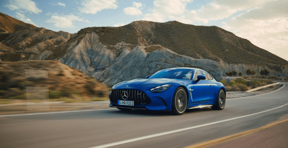 A blue Mercedes-Benz AMG GT Coupe speeding along a curved mountain highway.