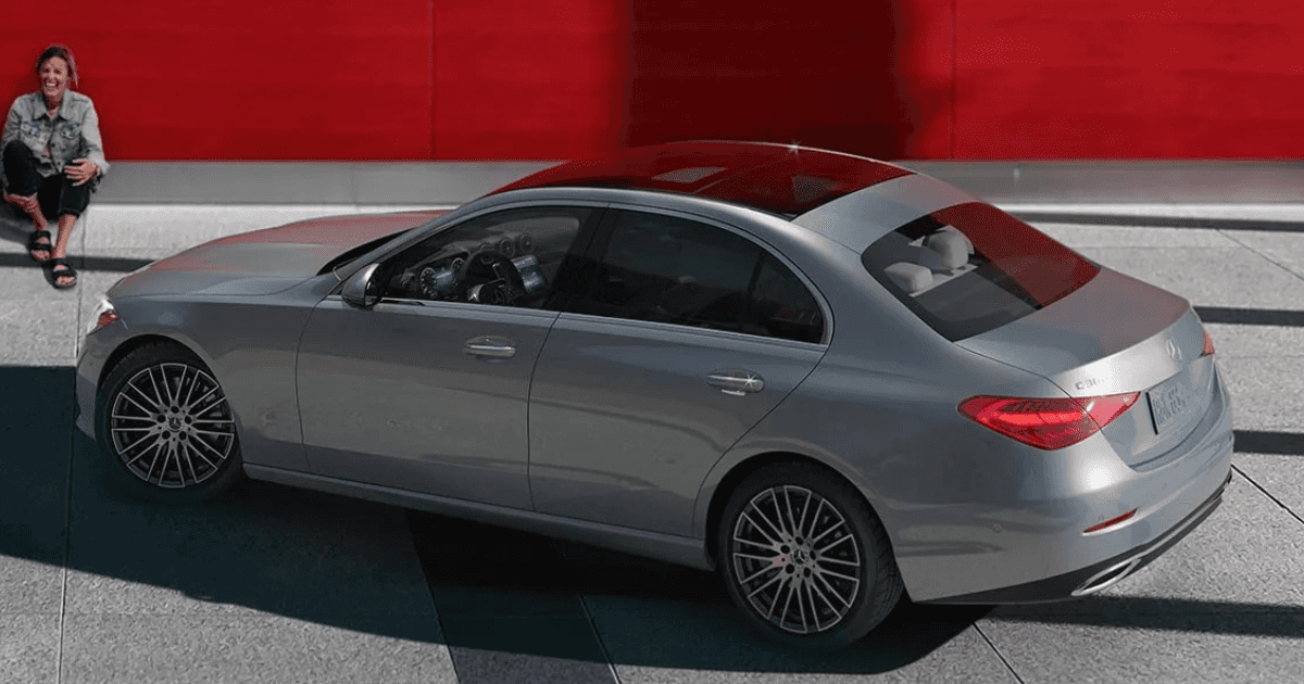 Two women sitting outside of a Mercedes-Benz C-Class