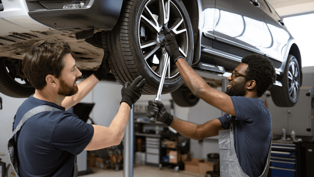 Technicians performing Mercedes-Benz maintenance on a vehicle