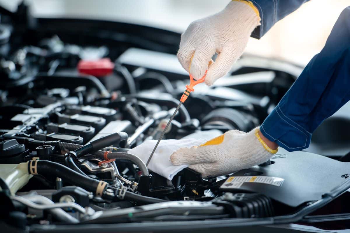 Technician performing an oil check on an engine