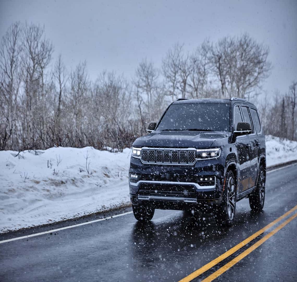 Black Jeep Grand Wagoneer SUV Trees