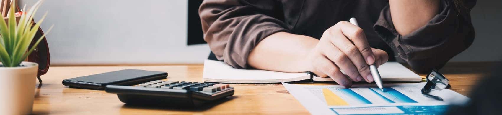 Woman calculating car financing at desk