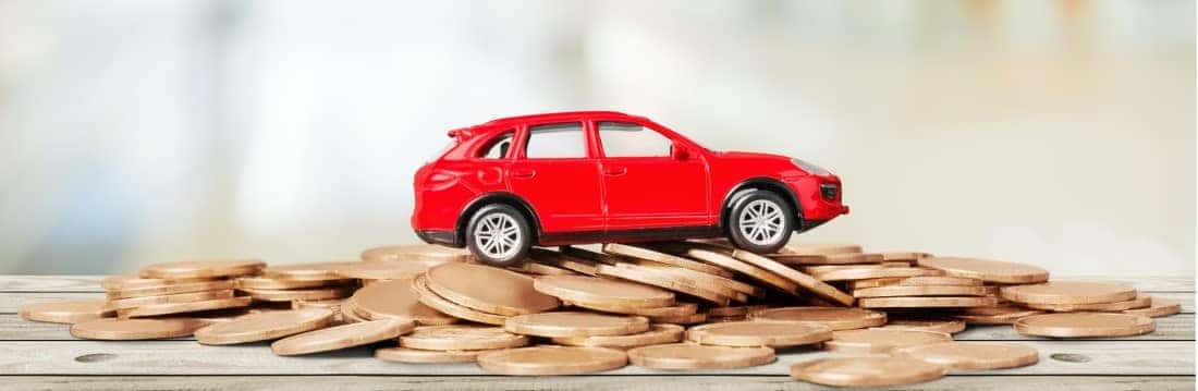 Red toy car sitting on pennies