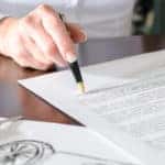 Woman reading a car purchase contract in car dealership