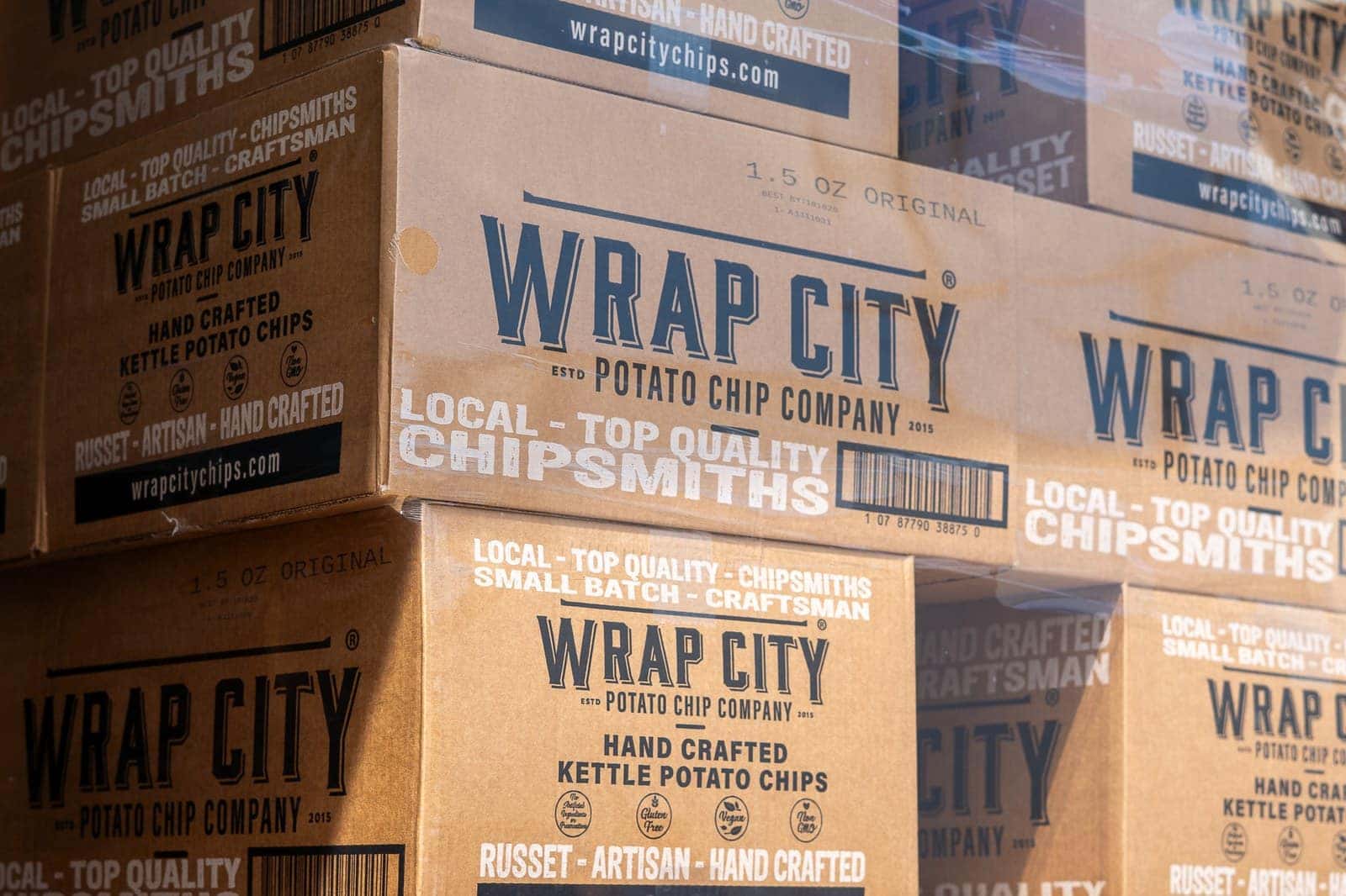 Close view of stacked Wrap City Potato Chip Company cases marked hand crafted kettle potato chips