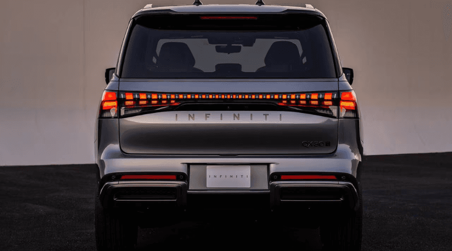 Rear exterior view of a metallic grey 2026 INFINITI QX80 luxury SUV displaying a full-width LED taillight bar and chrome INFINITI badging, highlighting second-row seating area equipped with Biometric Cooling in Ramsey, NJ.