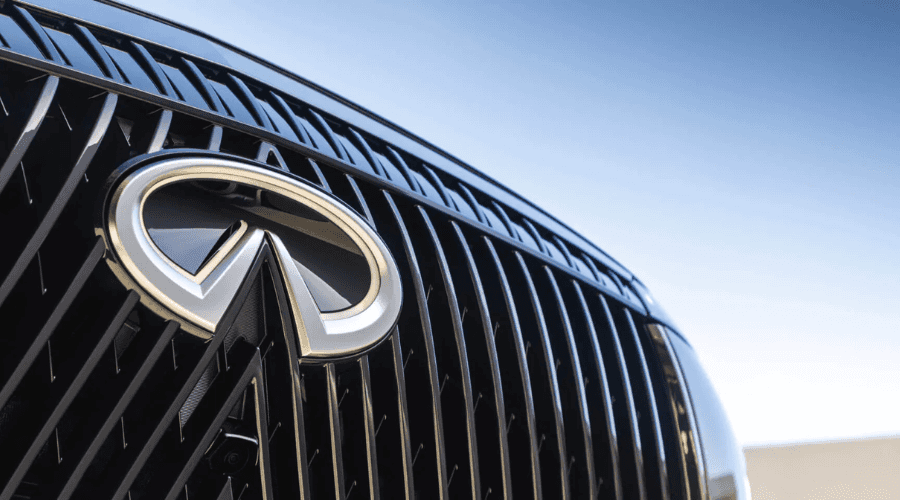 Close-up of the 2026 INFINITI QX80 double-arch front grille and iconic chrome emblem available at Ramsey INFINITI on Route 17