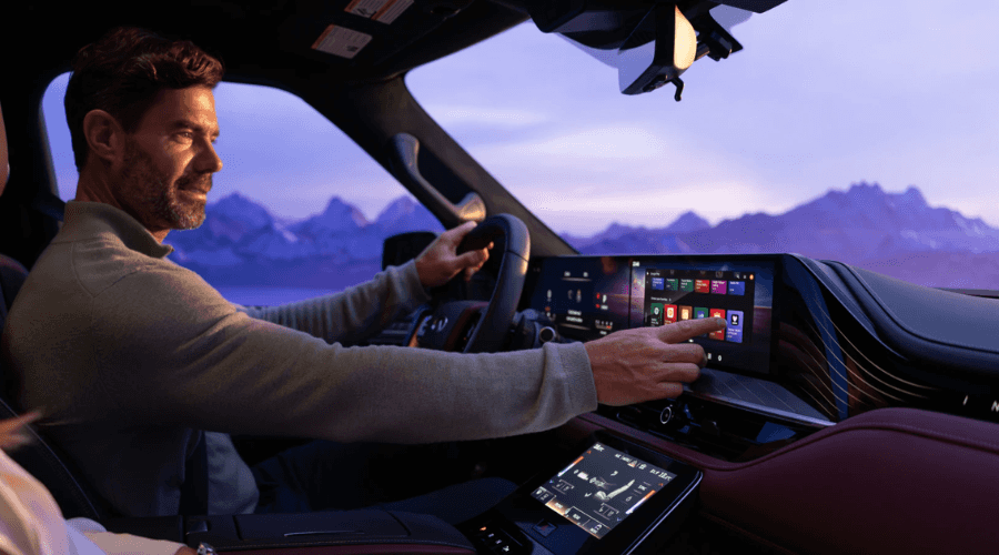 Driver interacting with the dual 14.3-inch Monolith touchscreen displays inside the 2026 INFINITI QX80 flagship interior, customizing app icons on the Google built-in dashboard at Ramsey INFINITI in Bergen County, NJ.
