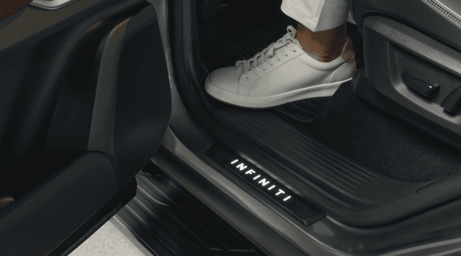 Close-up of the illuminated INFINITI door sill kick plate welcoming a driver stepping into the 2026 INFINITI QX80 luxury SUV cabin at Ramsey INFINITI in Bergen County, NJ.