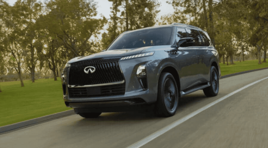 Front view of the 2026 INFINITI QX80 in low light featuring an illuminated front emblem and segmented LED headlights, providing enhanced visibility during dark autumn evening commutes in Ramsey, NJ.