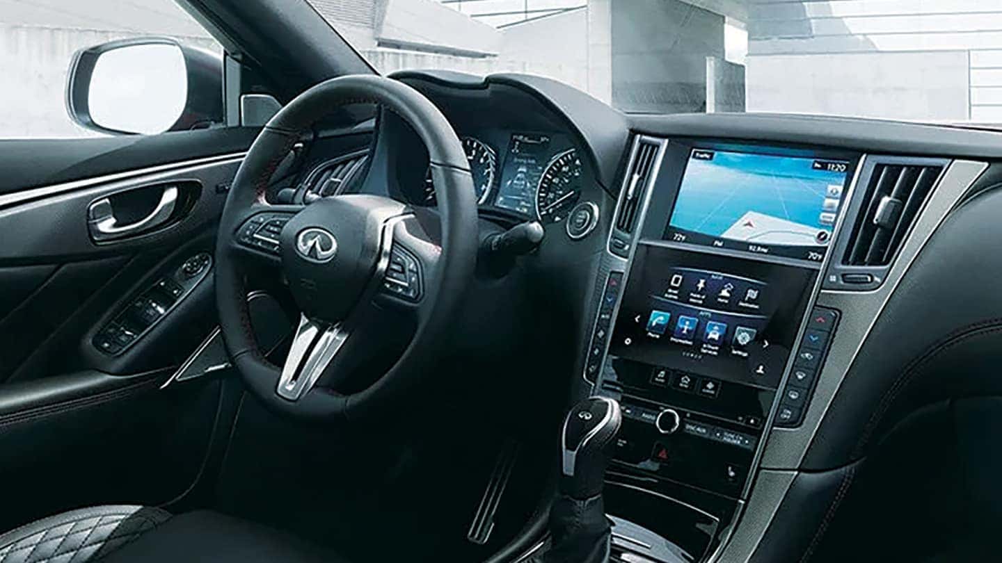Interior dashboard view of an INFINITI Q50 highlighting the dual-screen infotainment system and steering wheel controls.
