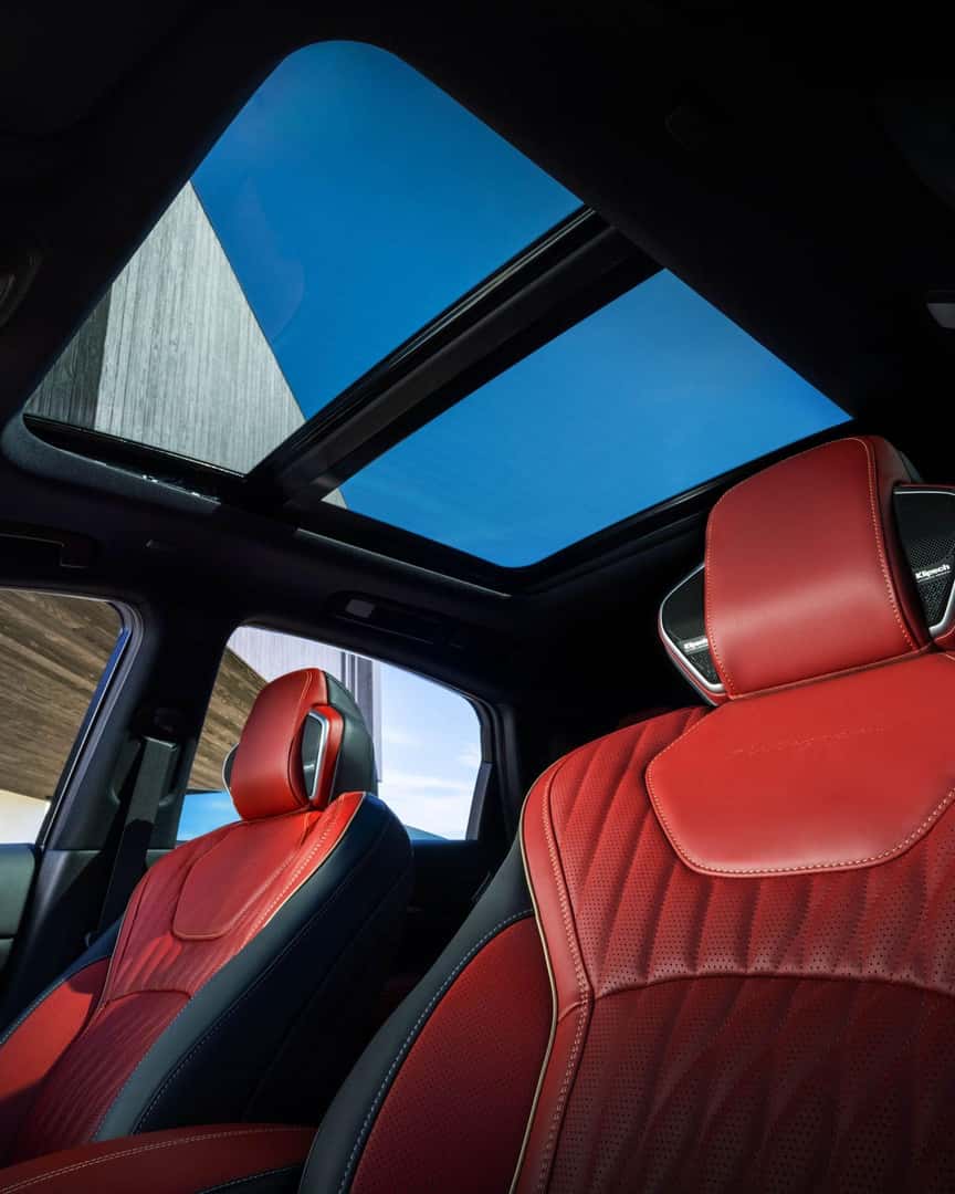 Front cabin of the 2027 INFINITI QX65 featuring red leather seats, panoramic moonroof, and upscale two-tone interior design.